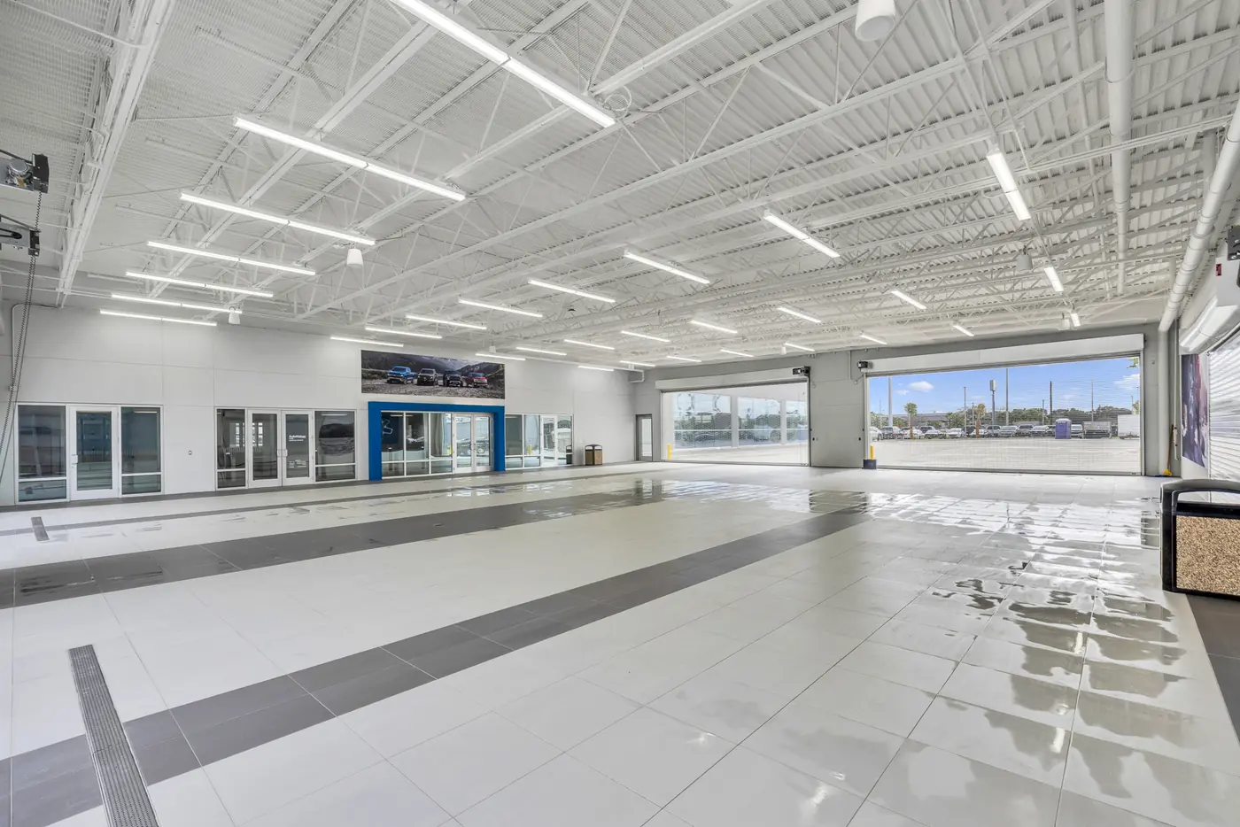 Bright white dealership service drive with exposed painted ceiling