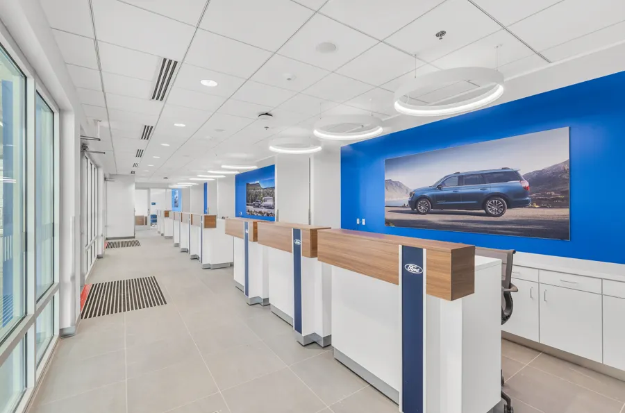 Service write-up lanes with blue feature walls at a Ford dealership finished by Aldana Painting Co