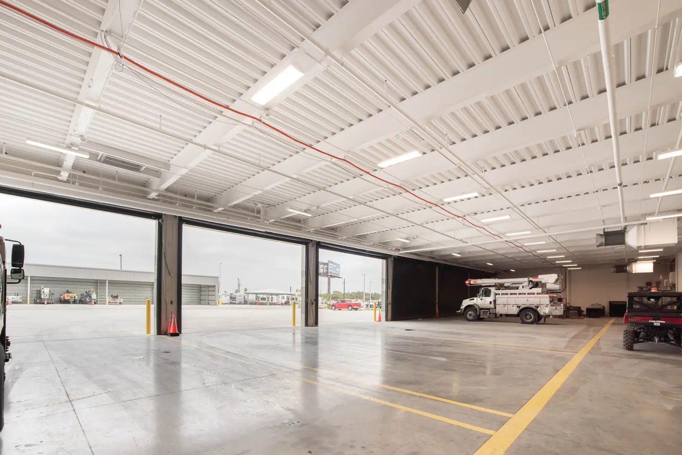 Finished vehicle bay with open overhead doors at a utility service center